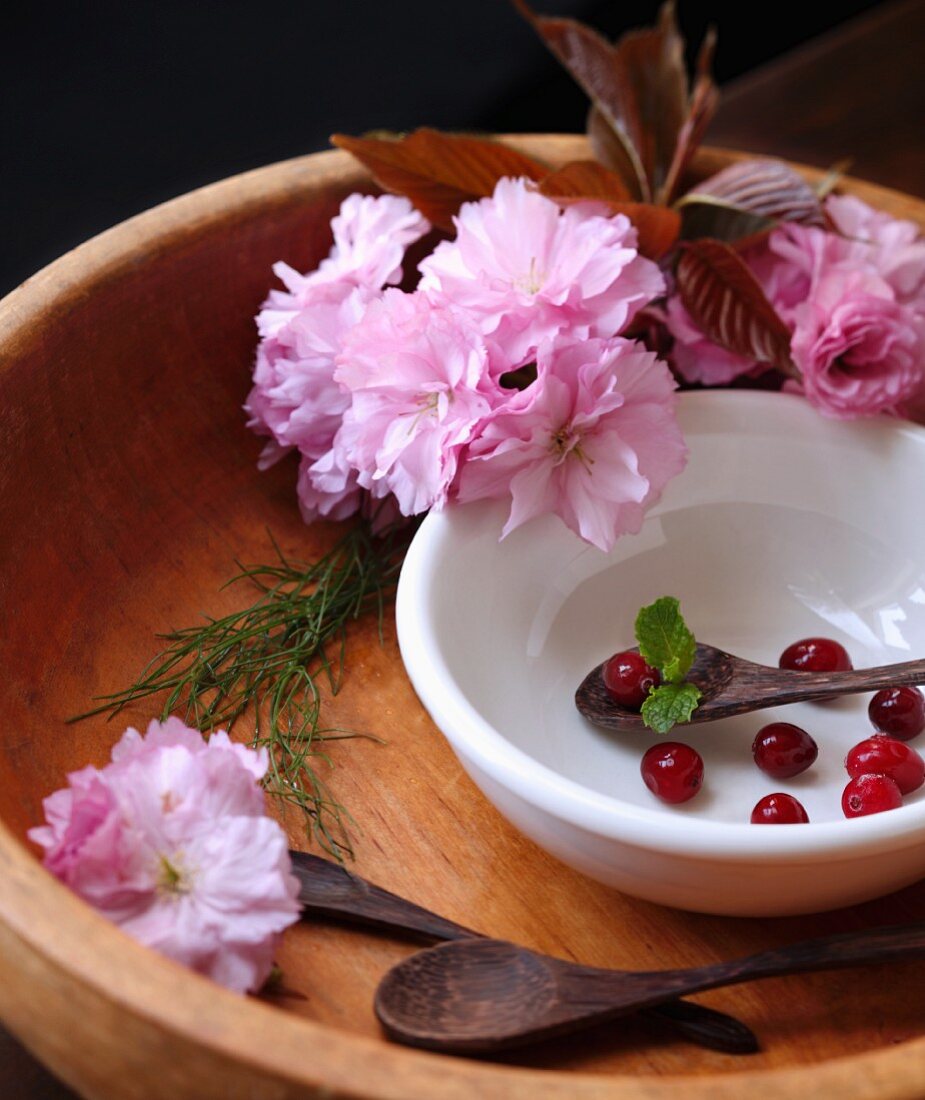 Holzschale mit Kirschblüten und Cranberries