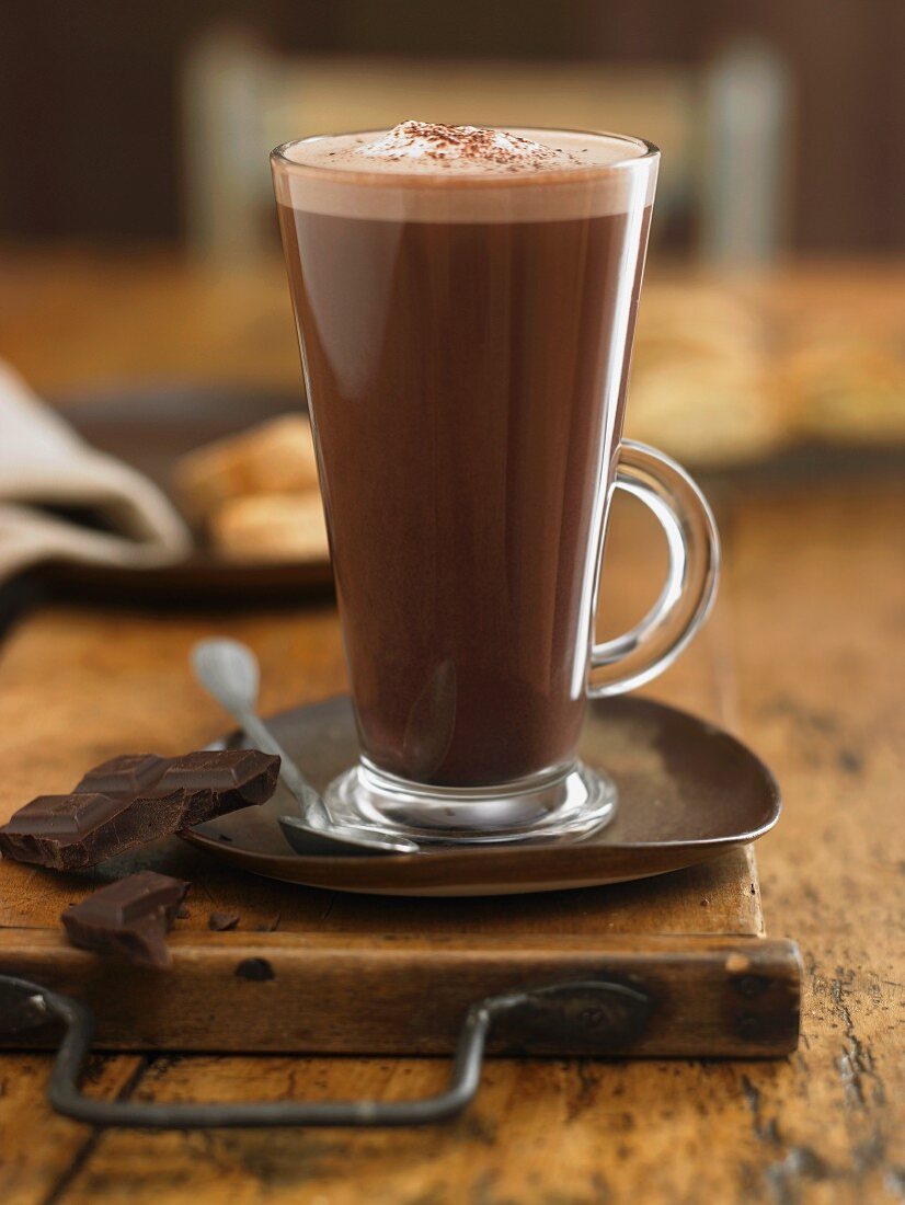 A glass of hot chocolate and pieces of chocolate
