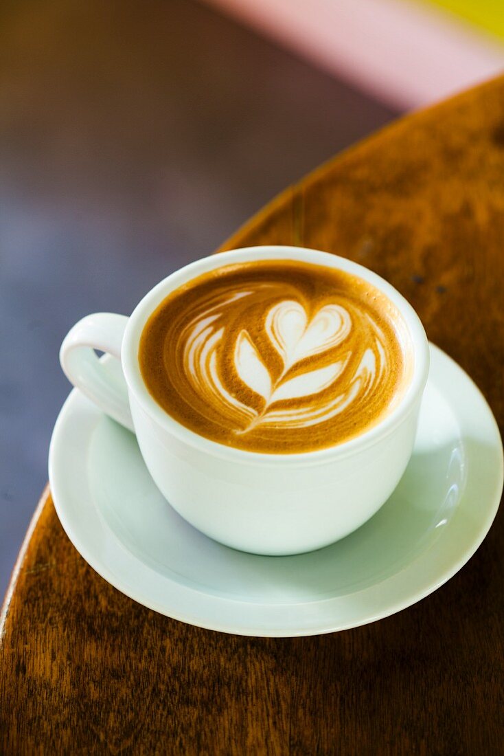 Latte with a Flower Design in a White Mug on a White Saucer