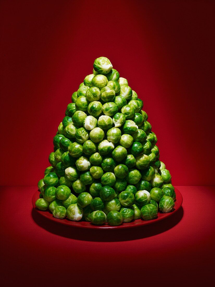 A pyramid of Brussels sprouts on a red plate