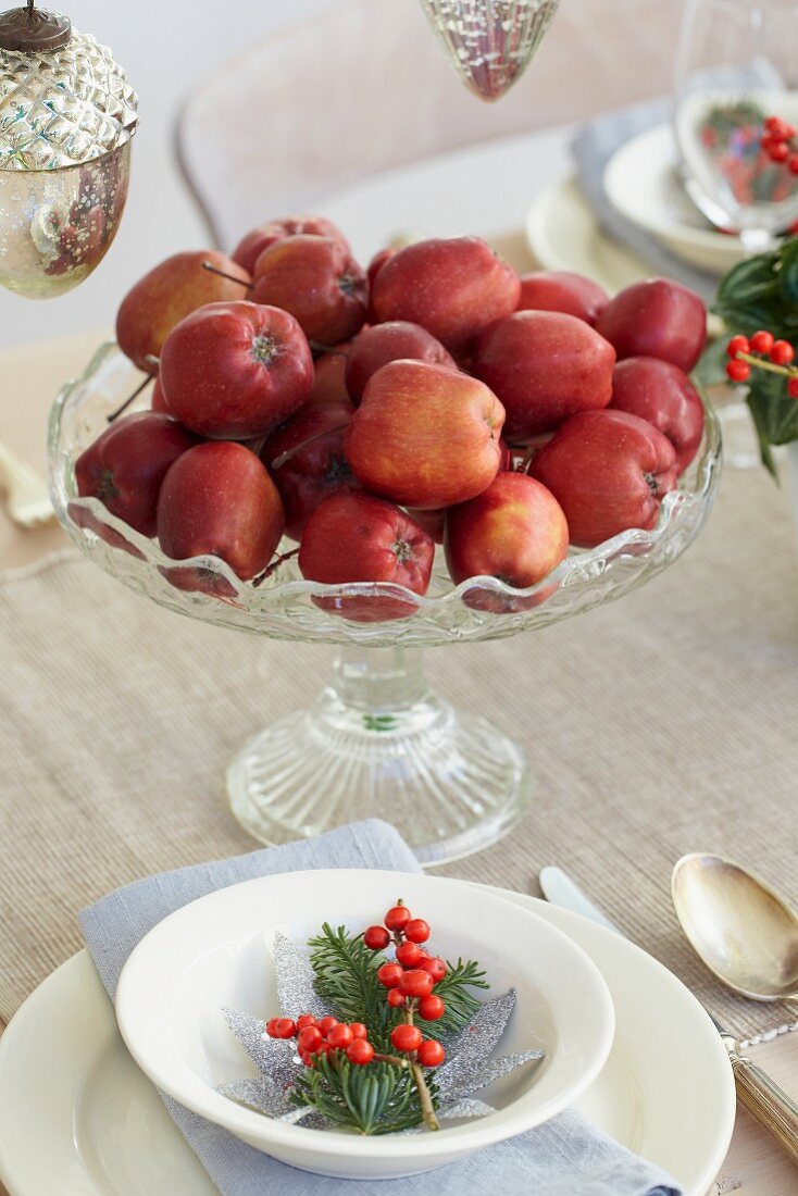 Rote Äpfel als Tischdeko auf weihnachtlich gedecktem Tisch