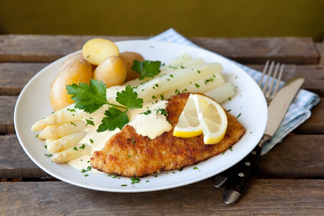 White asparagus and a schnitzel with Hollandaise sauce and potatoes