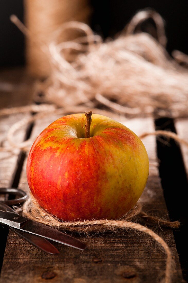 An apple with string and scissors