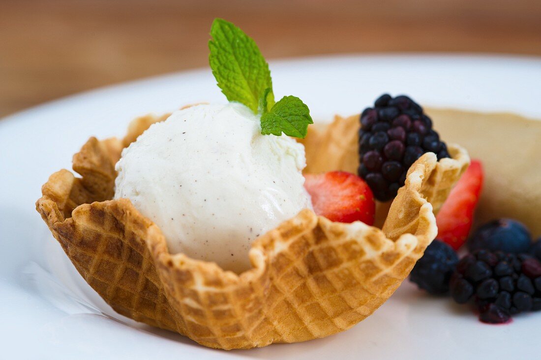 A wafer basket with vanilla ice cream and berries