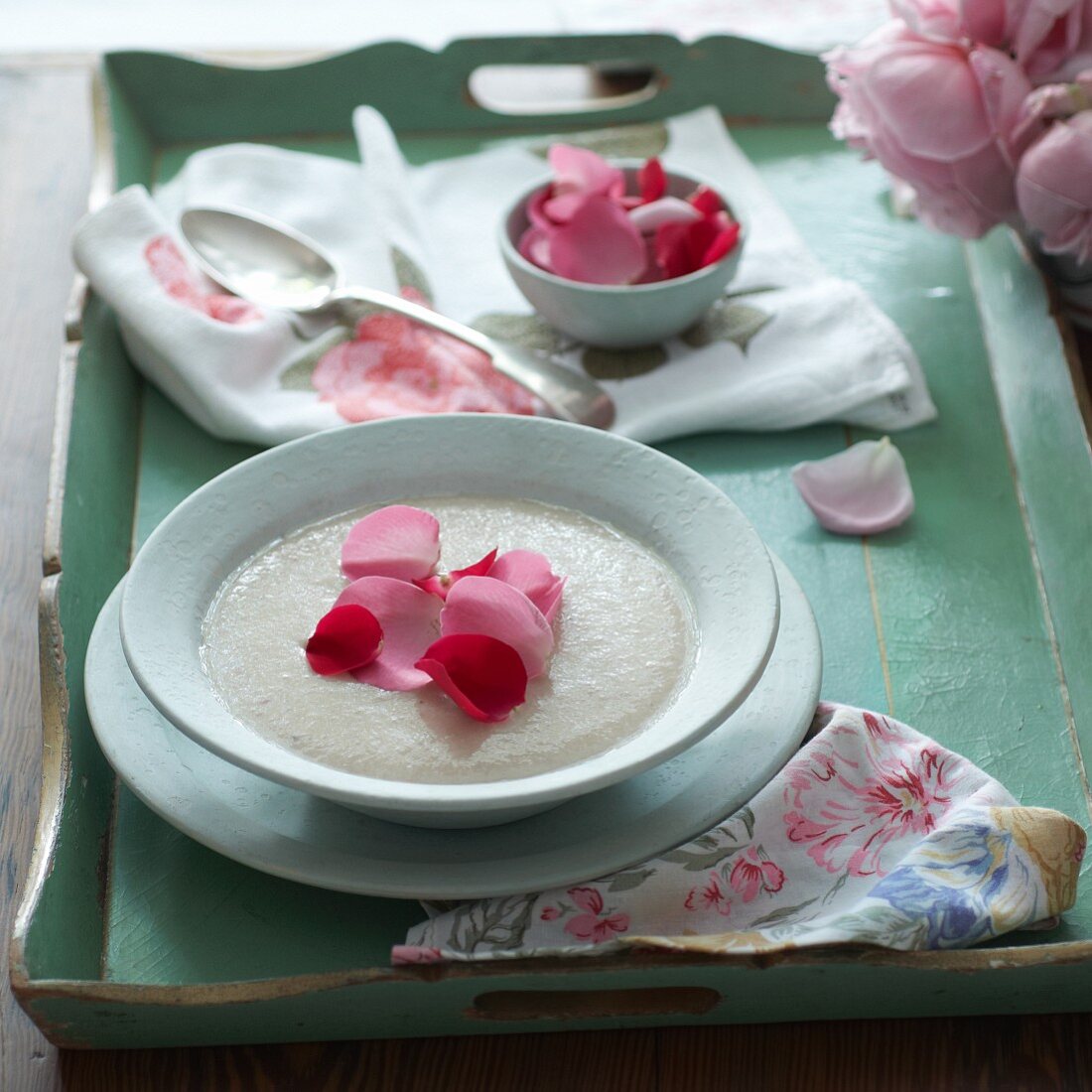 Suppe mit Rosenblütenblättern auf Tablett