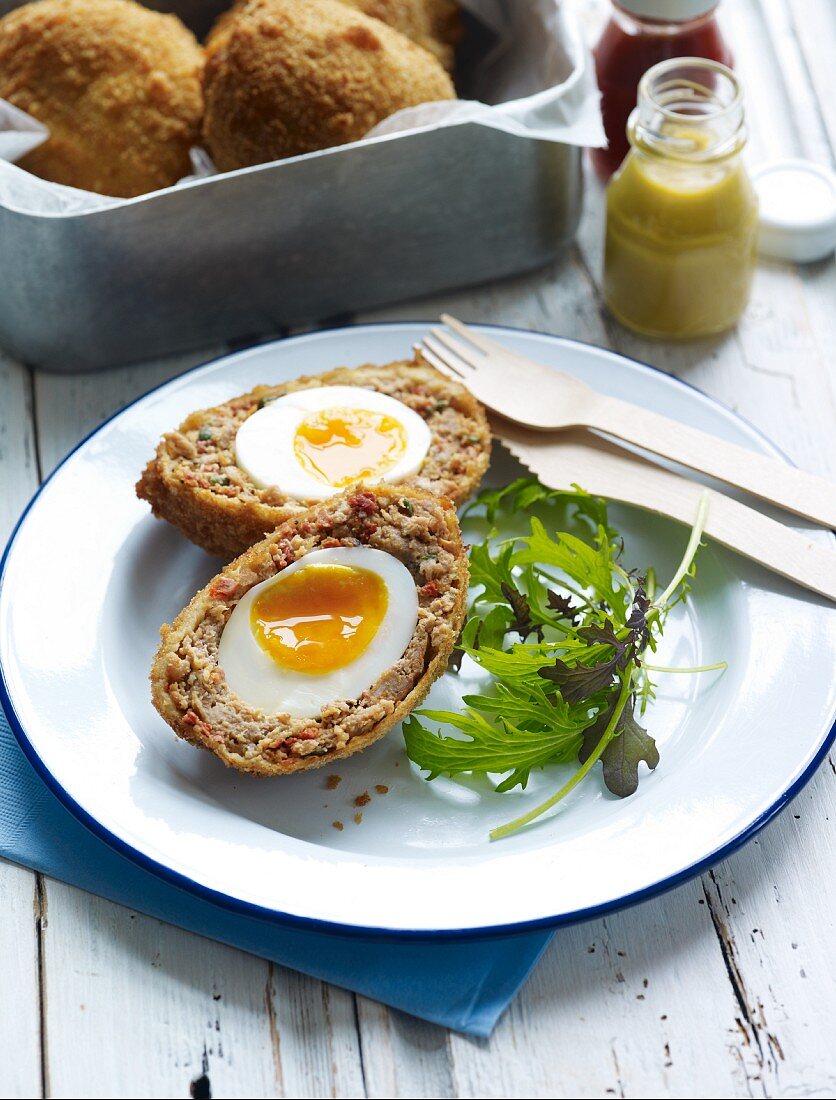 A Scotch egg with salad leaves