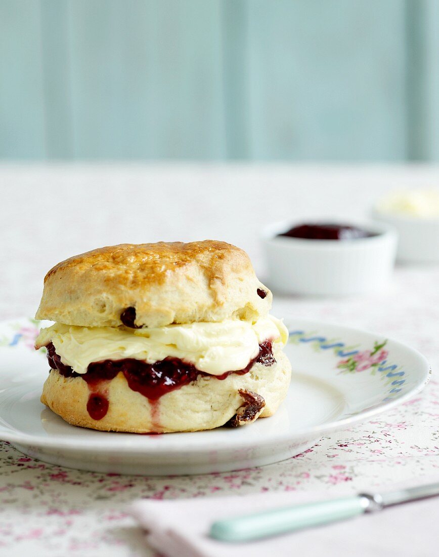 A scone with clotted cream and jam