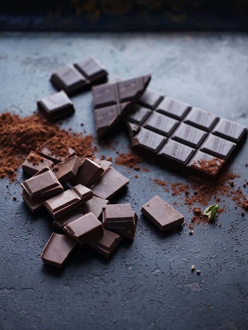 Pieces of chocolate, a bar of chocolate and cocoa powder