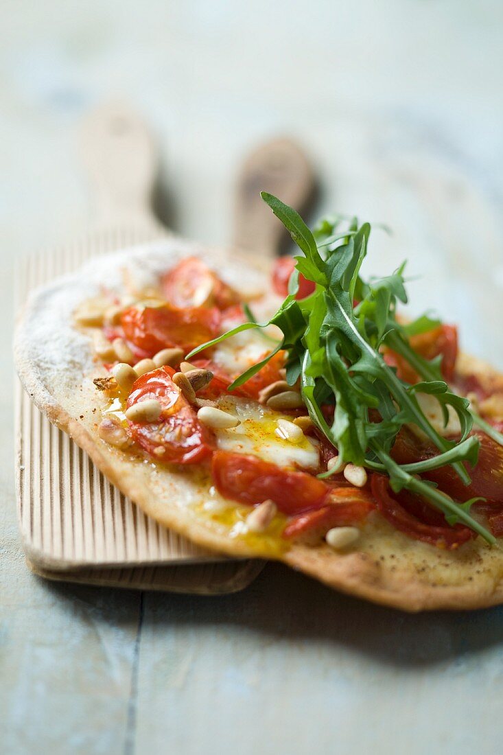 Small pizza topped with rocket and pine nuts