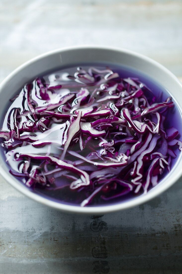 Sliced red cabbage in a bowl of water