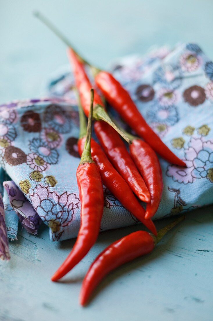 Fresh red chillies on a floral-patterned cloth