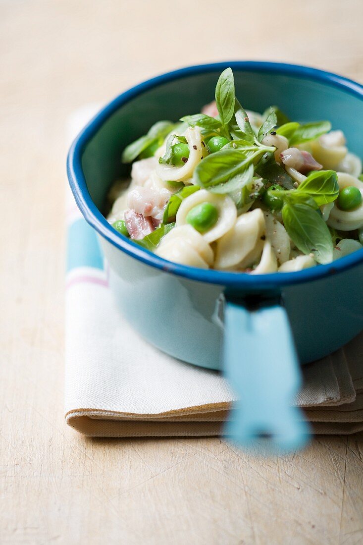 Orecchiette with peas and basil in a saucepan