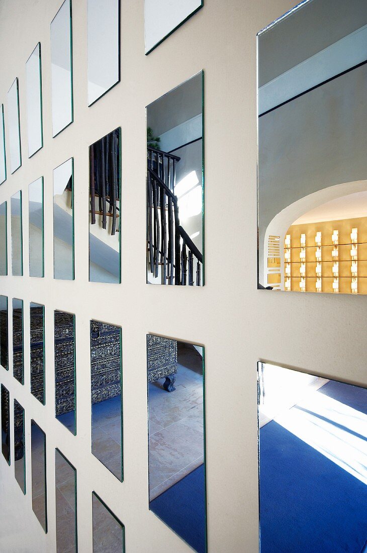 Reflections in grid of square mirrors on wall