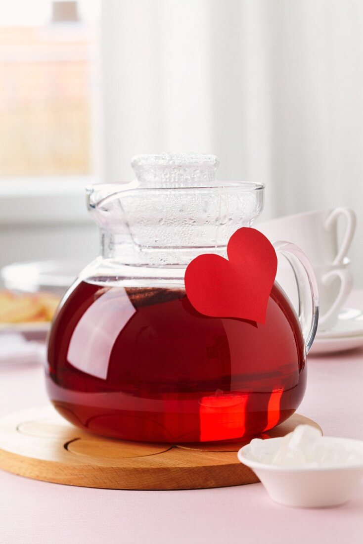 A tea pot decorated with a paper heart