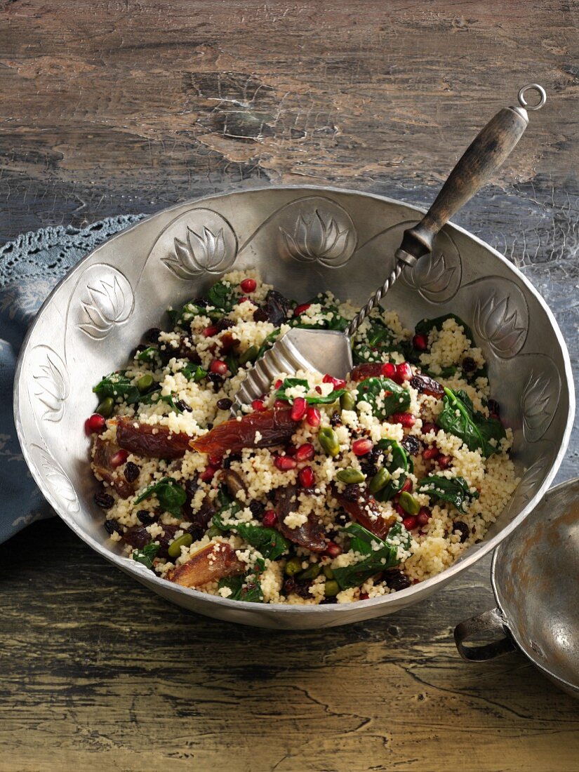 Couscous salad with spinach, dates and pomegranate seeds