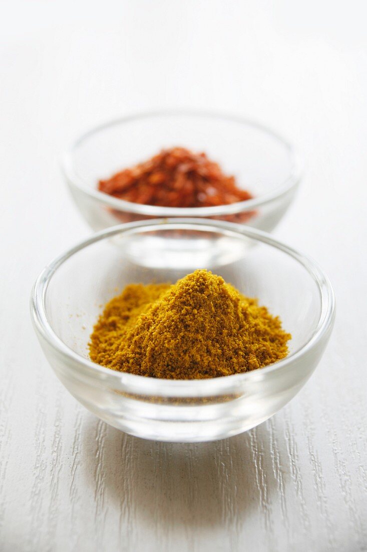Curry powder and chilli powder in small glass bowls