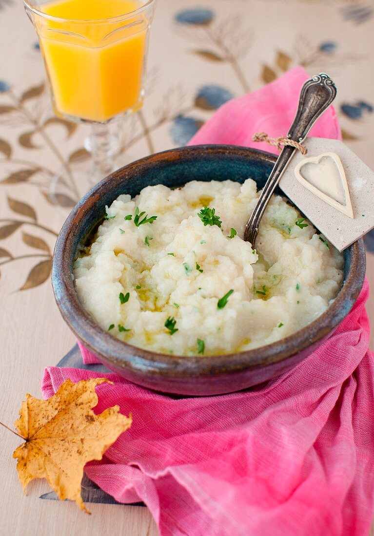 A Bowl of Mashed Turnips with Truffle Oil and Parsley; Spoon