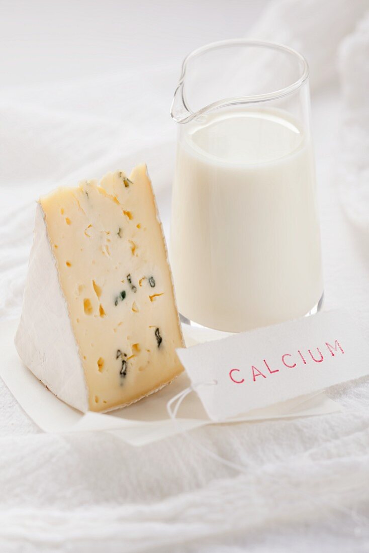 Blauschimmelkäse und Milch mit einem Kalzium-Schild
