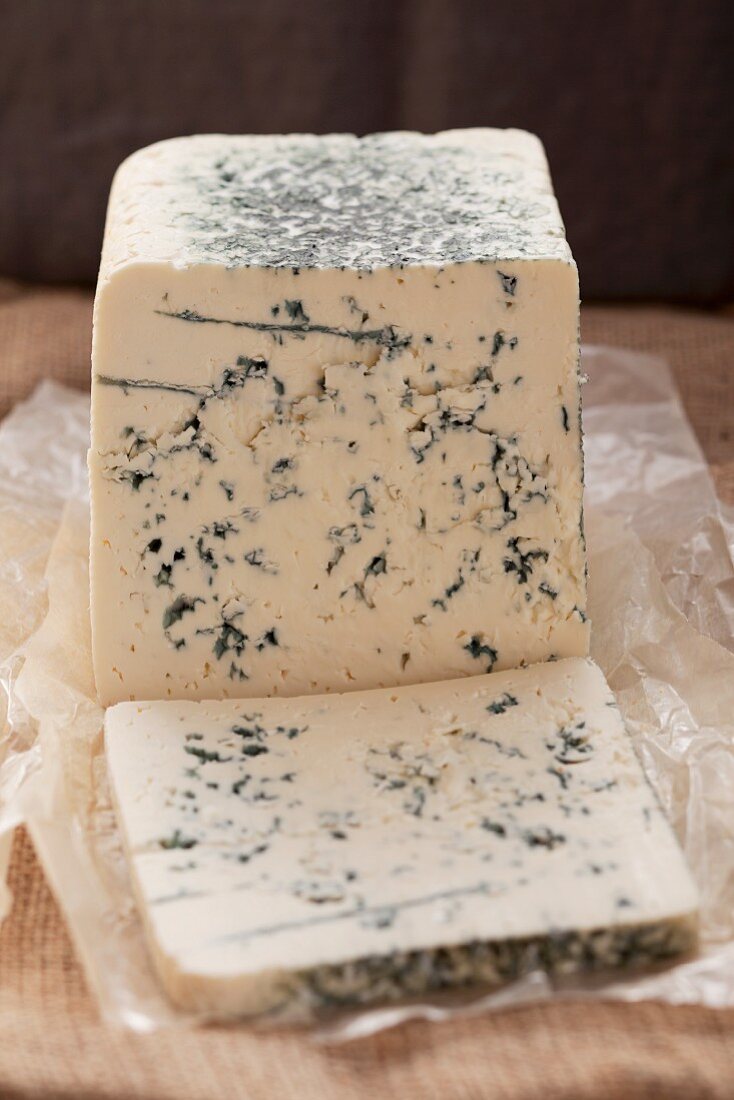 Blue cheese, partly slices, on paper