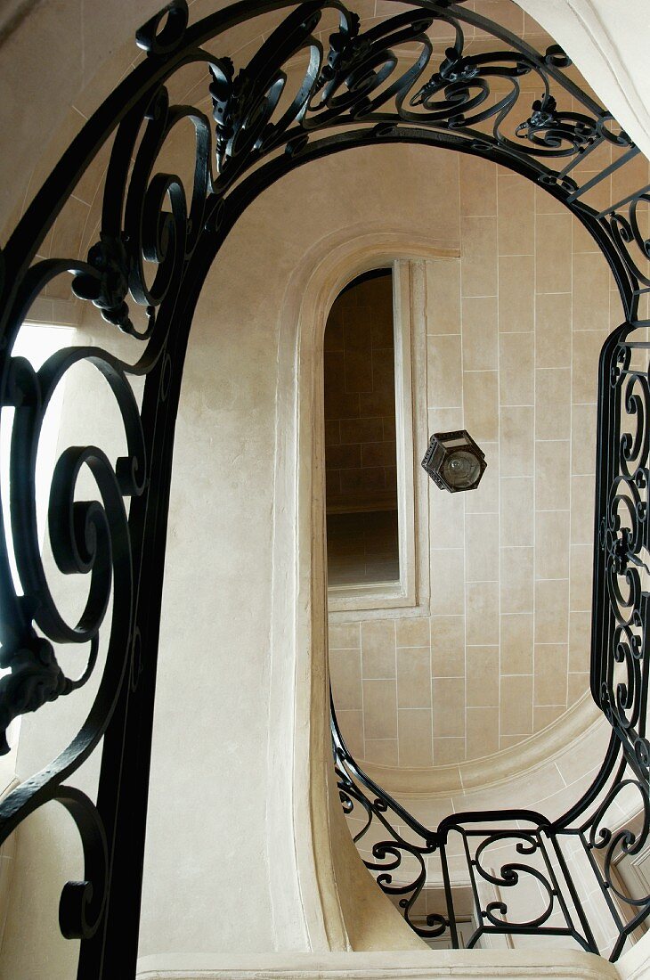 View up through oval stairwell with wrought iron balustrade in grand house