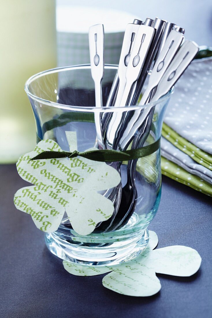 Teaspoons in glass decorated with paper clover leaves
