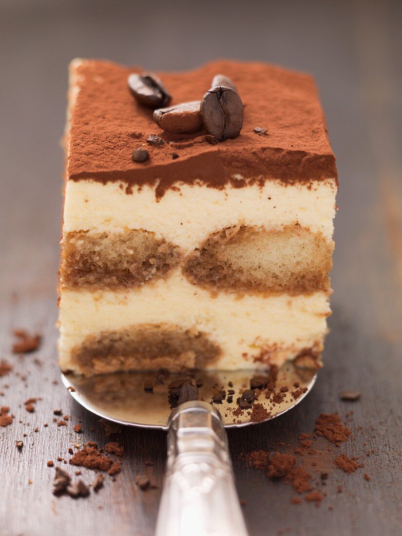 A piece of tiramisu with mocha beans on a cake slice