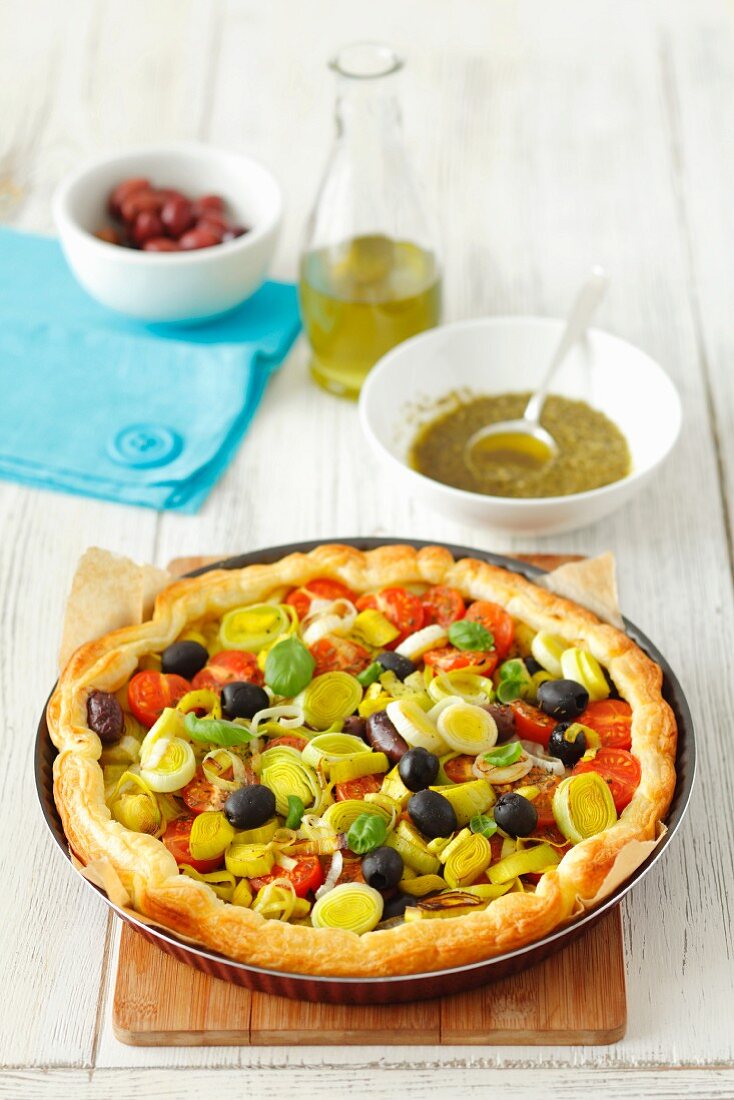 Puff pastry tart with tomatoes, leek, olives and basil pesto
