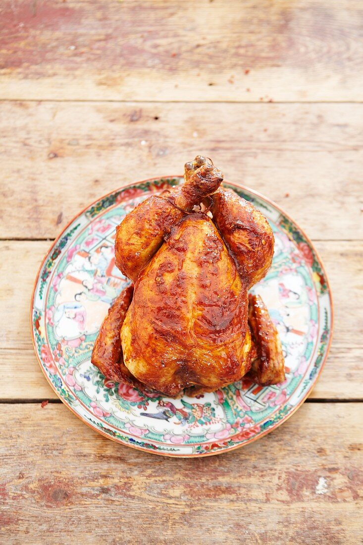 A whole roast chicken on a ceramic dish