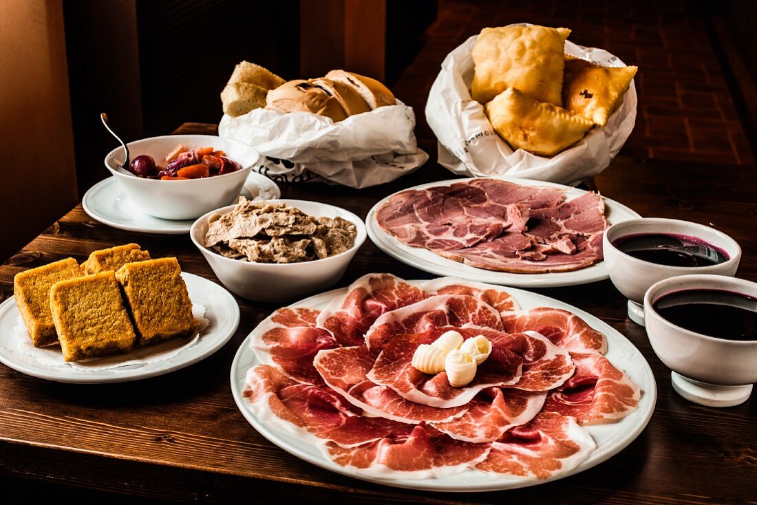 Vorspeisen aus Italien: Schinken, Salami, Brot, Oliven, Aufstrich und Saucen