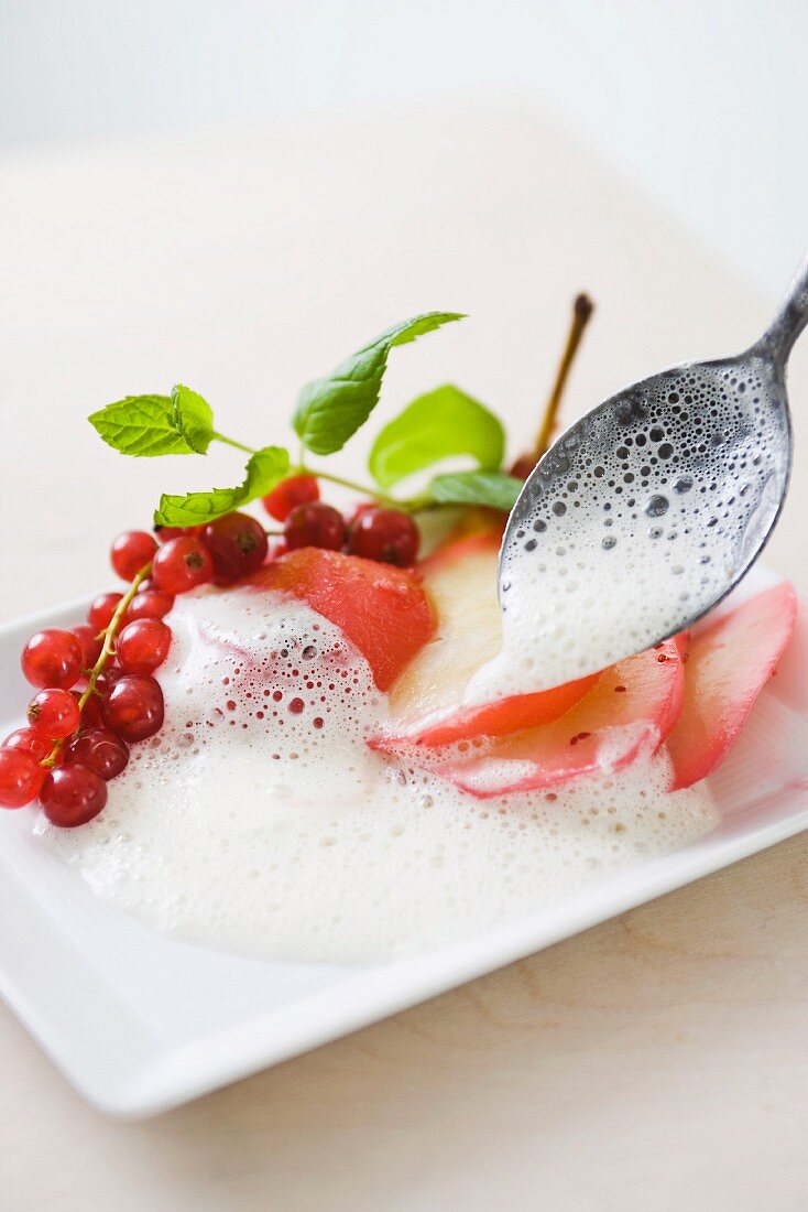 Red pears with vanilla foam and redcurrants