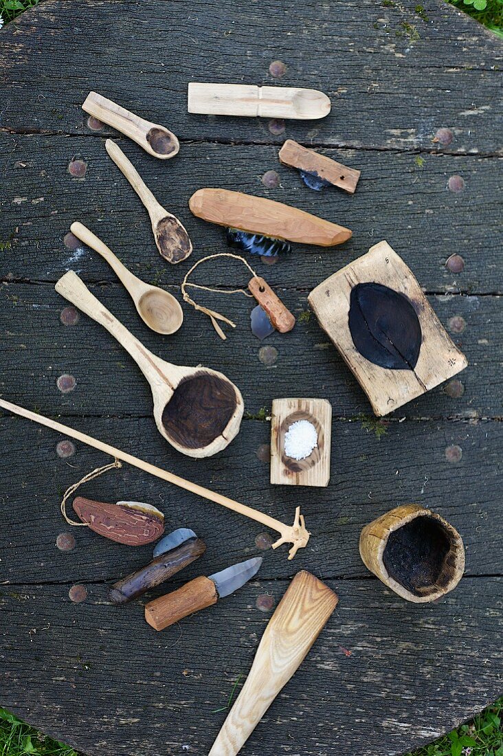 Selbst hergestellte, rustikale Küchenutensilien auf Holzplatte