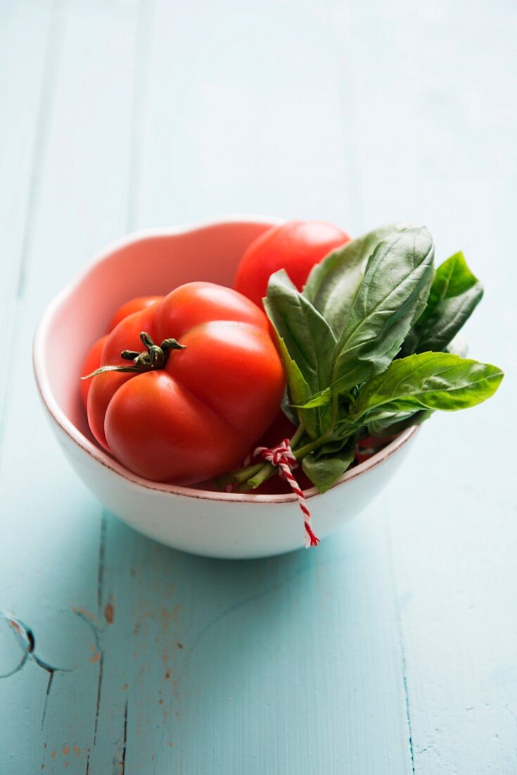 Tomaten und frisches Basilikum im Schälchen