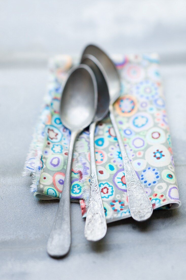 Three spoons on a patterned cloth