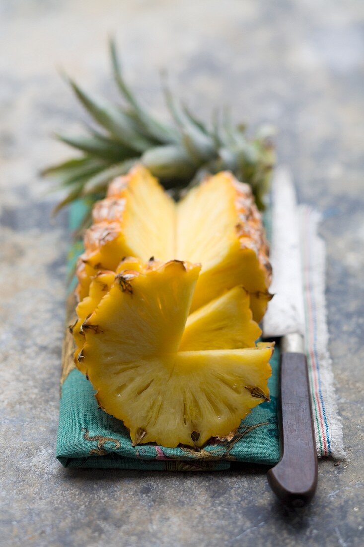 A fresh pineapple, partly sliced