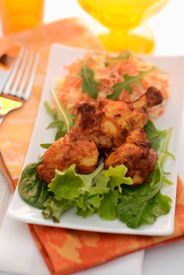 Spicy chicken legs with a salad of raw vegetables