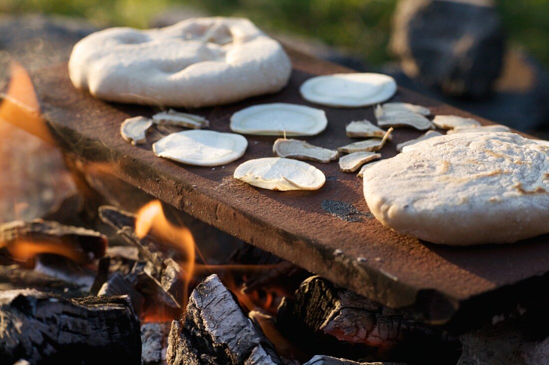 Chapati being baked on hot metal over an open fire