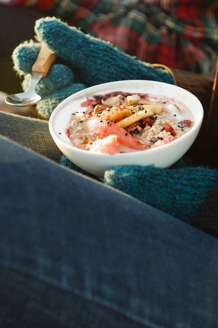 Frau isst Bircher Müsli mit Winterfrüchten