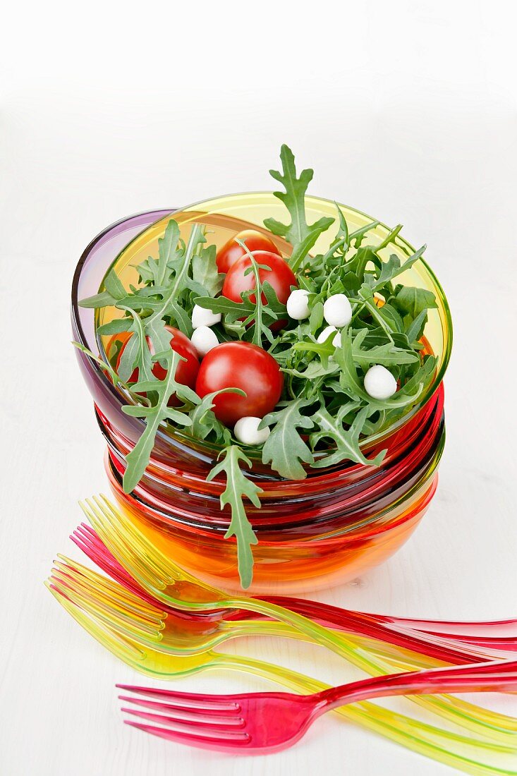 Cherry tomatoes on a bed of rocket with mozzarella pearls