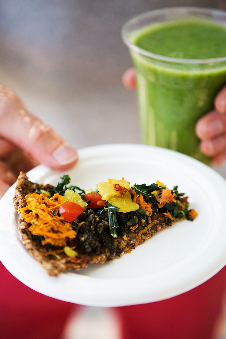 Vollkornpizza mit rohem Gemüse und grünem Smoothie