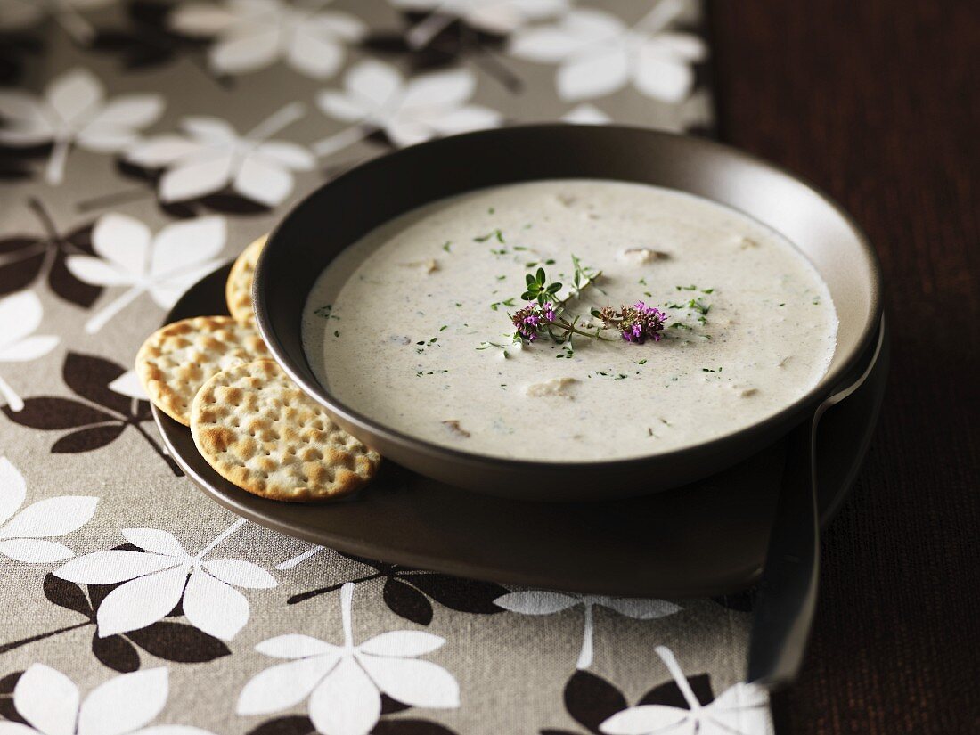 Cream of mushroom soup with herb flowers and crackers