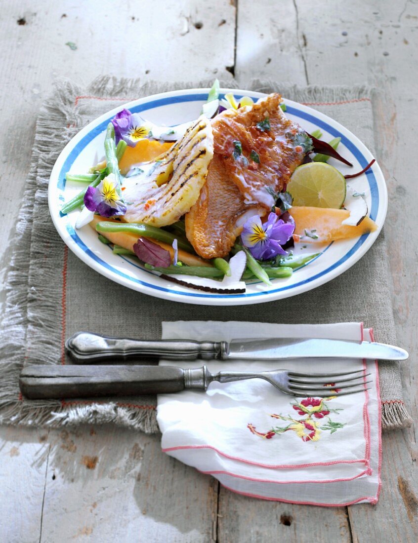 Bohnensalat mit gegrillter Ananas, Mango und Rotbarbenfilet in Rohschinken