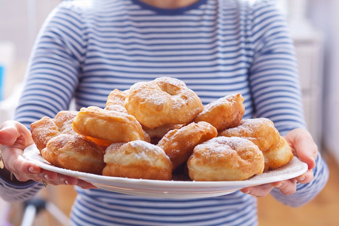 Frau hält Tablett mit bulgarischen Krapfen