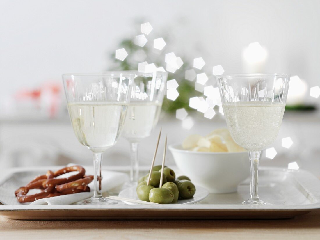 White wine spritzer in wine glasses with nibbles