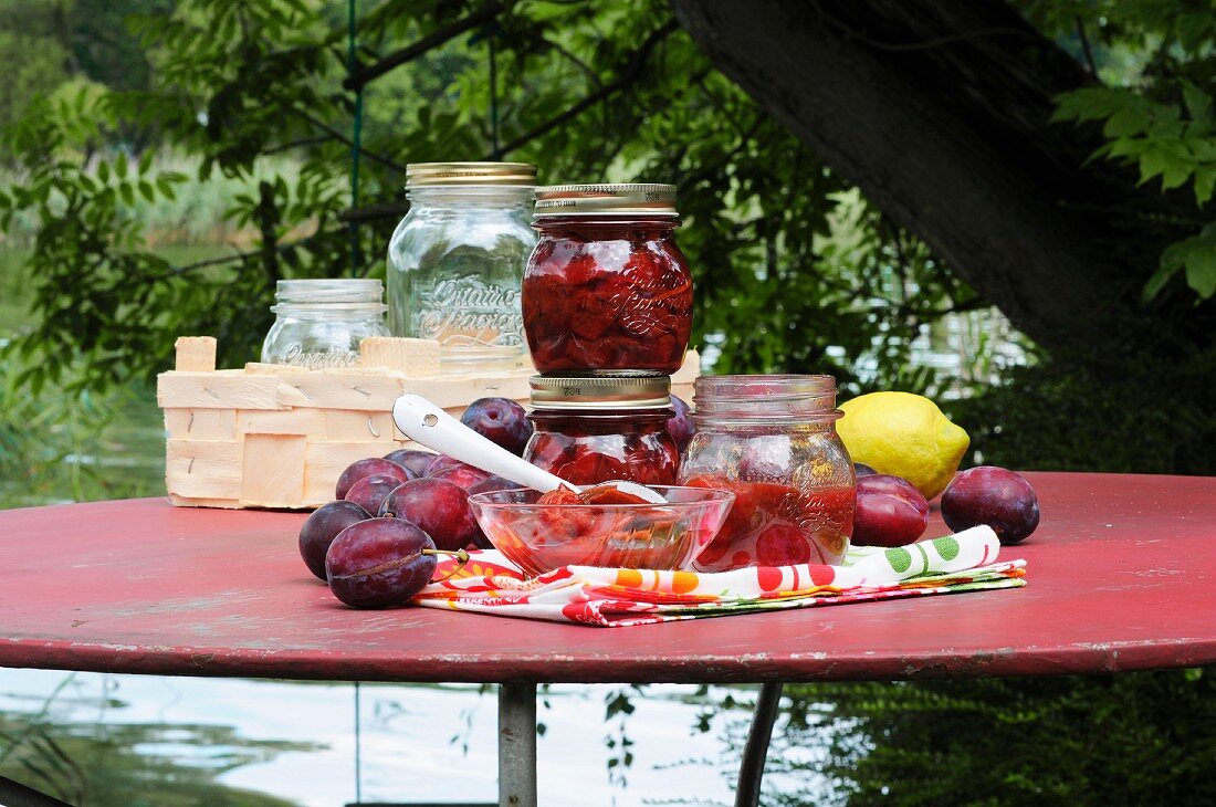 Preserved plums in jars on a table in the garden