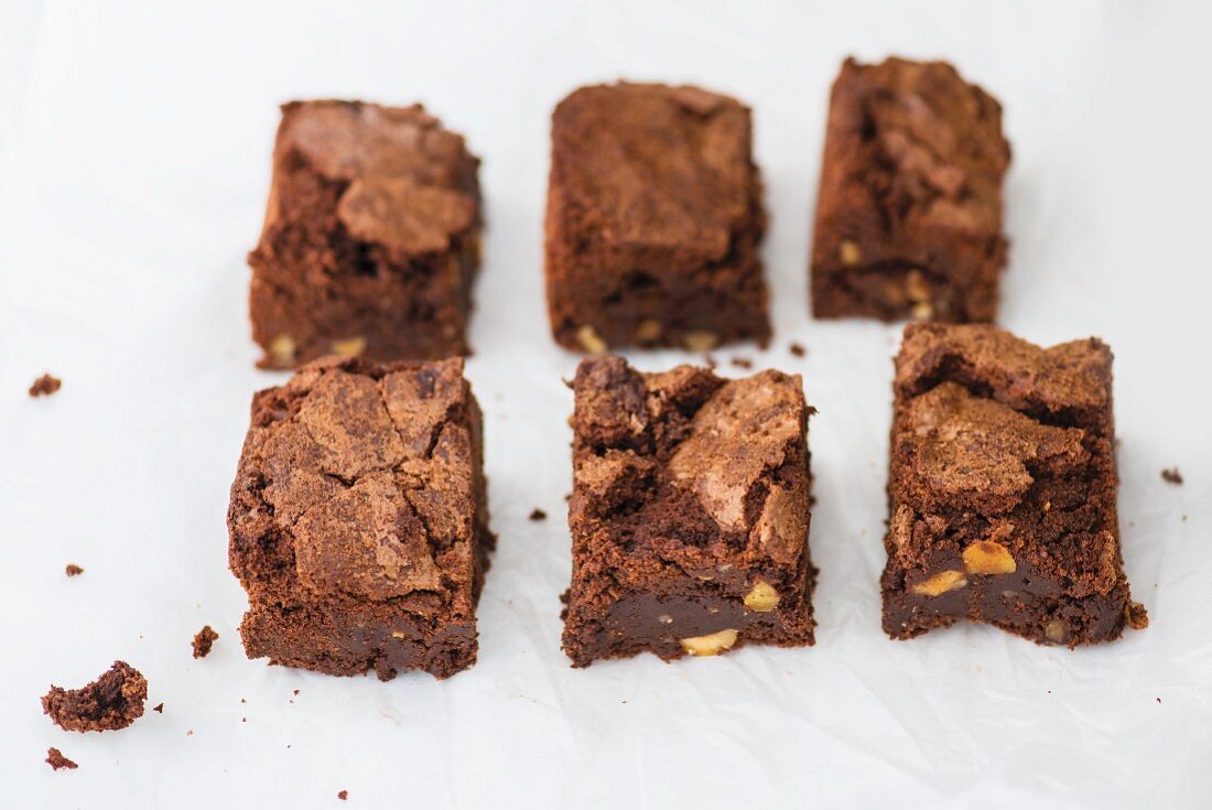 Six chocolate brownies on paper