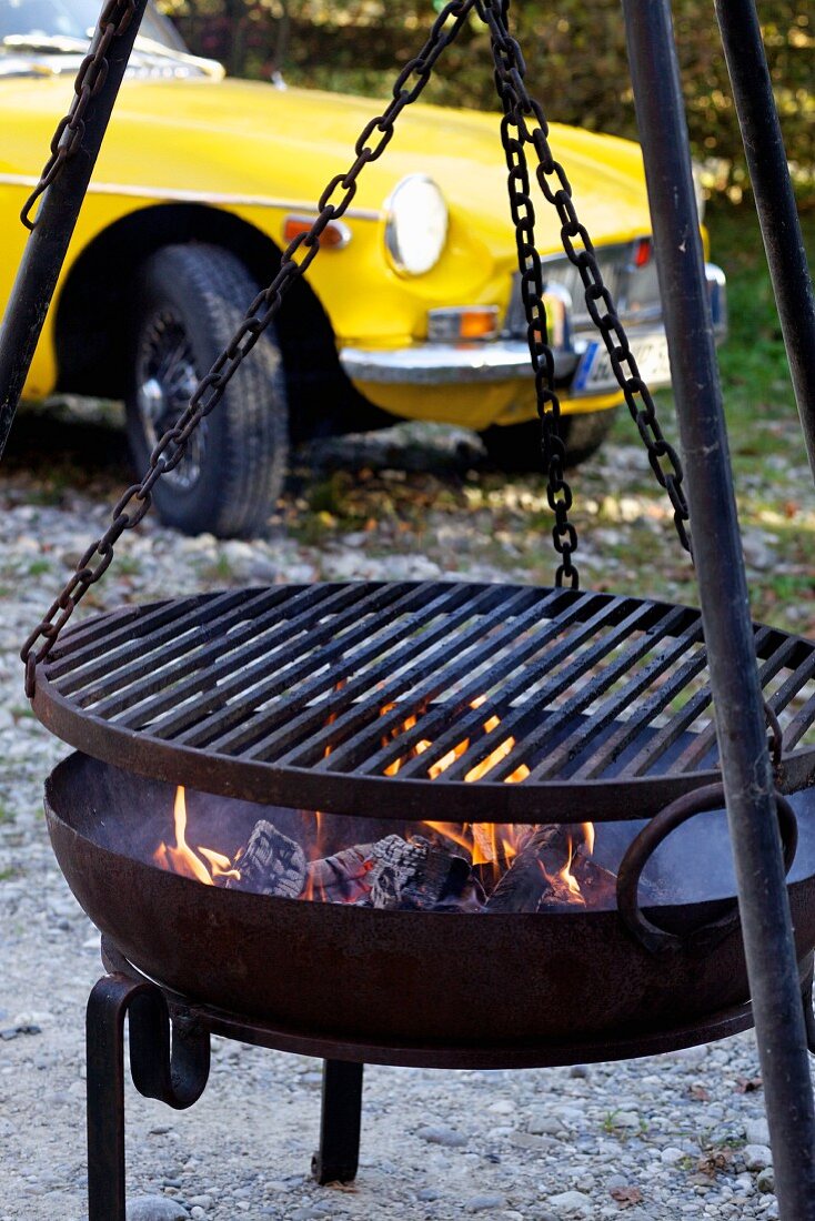 Ein Grill, im Hintergrund gelber Oldtimer