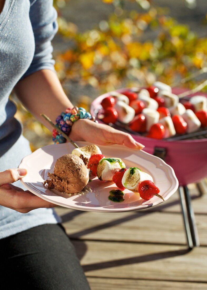 Barbecued strawberry and marshmallow skewers with chocolate ice cream