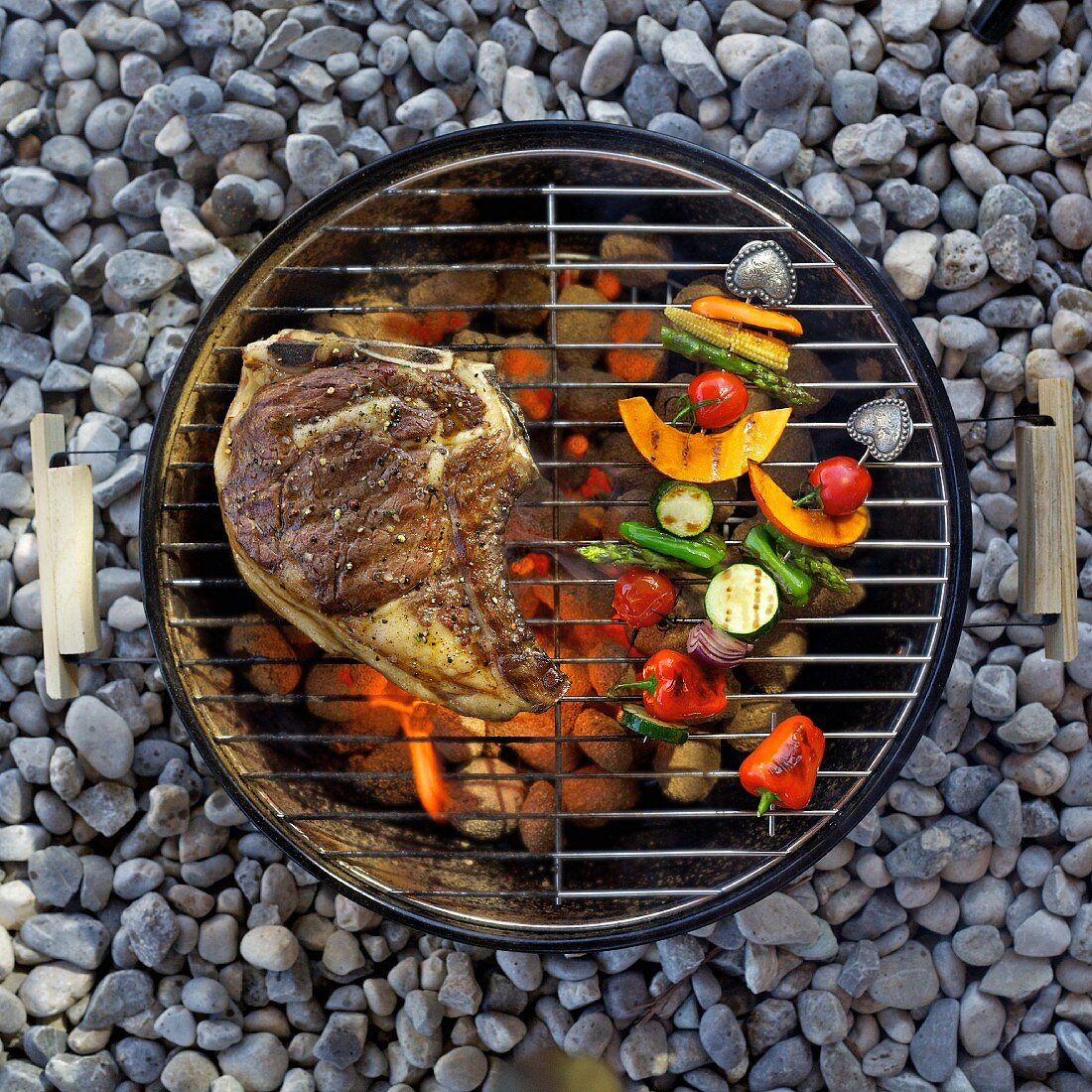 A T-bone steak and vegetables on the barbecue