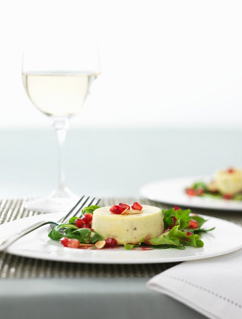 Individual Stilton tart with pomegranate seeds and rocket