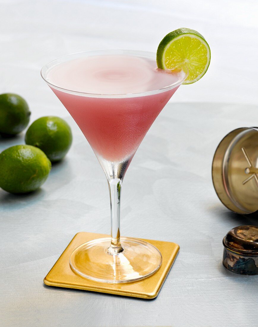A Cosmopolitan on a Coaster with a Lime Slice Garnish